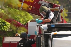 Federal, state and local law enforcement agents and explosives experts load boxes of improvised explosive devices from James Holmes' apartment into a sand-filled dump truck Federal, state and local law enforcement agents and explosives experts load boxes of improvised explosive devices from James Holmes' apartment into a sand-filled dump truck