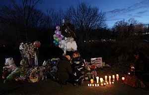 Mourners kneel at a makeshift memorial in Newtown, CT Mourners kneel at a makeshift memorial in Newtown, CT