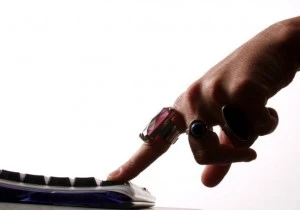 A woman's finger pressing a keyboard A woman's finger pressing a keyboard
