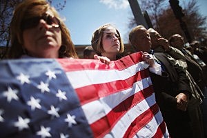 Jaime Caputo (C) holds an American flag outside the funeral for 29-year-old Krystle Campbell in Medford, Massachusetts Jaime Caputo (C) holds an American flag outside the funeral for 29-year-old Krystle Campbell in Medford, Massachusetts