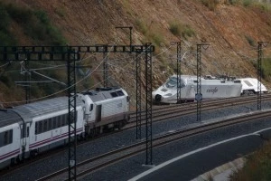 A train passes the wreckage of the high speed Renfe train A train passes the wreckage of the high speed Renfe train