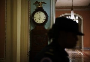 A Capitol Hill Police officer passes by the Ohio Clock which shows the time has just passed midnight on the Senate side of the U.S. Capitol A Capitol Hill Police officer passes by the Ohio Clock which shows the time has just passed midnight on the Senate side of the U.S. Capitol