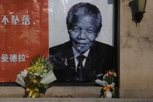 Flowers are placed in front of an image of former South African president Nelson Mandela at the Embassy of South Africa on December 6, 2013 in Beijing, China Flowers are placed in front of an image of former South African president Nelson Mandela at the Embassy of South Africa on December 6, 2013 in Beijing, China