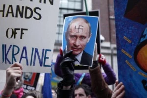 People hold signs during a protest in front on the Russian Consulate against Russian military intervention in the Crimea region of Ukraine in New York City. People hold signs during a protest in front on the Russian Consulate against Russian military intervention in the Crimea region of Ukraine in New York City.