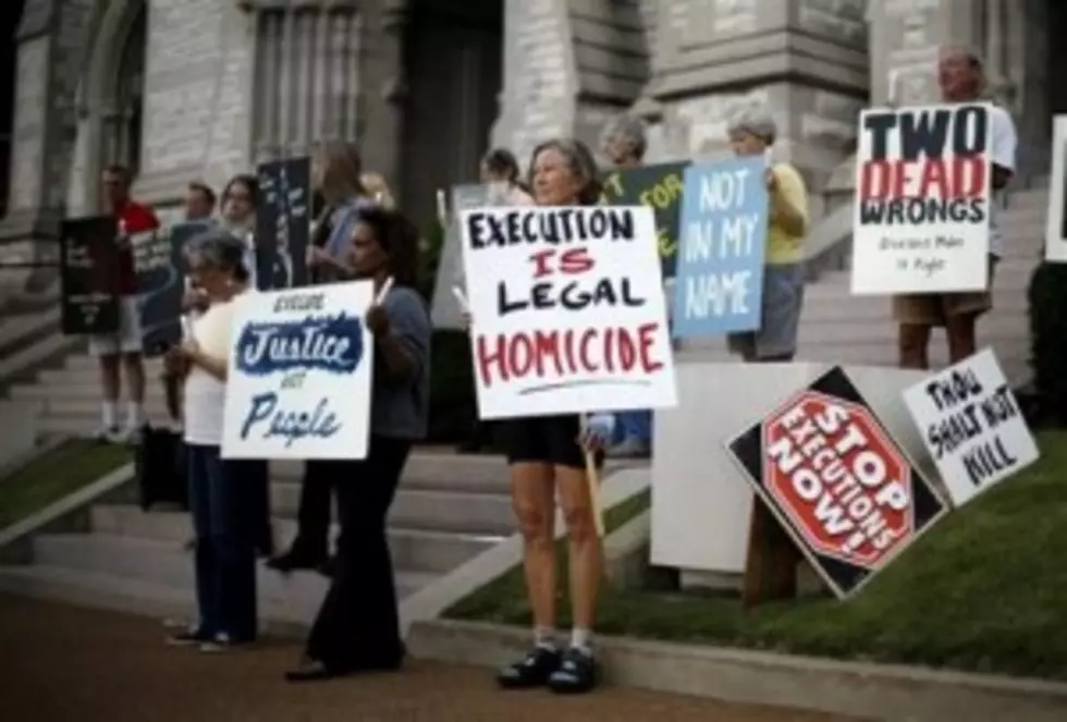 A group of death penalty opponents held a vigil outside St. Francis Xavier College Church hours before the scheduled execution of Missouri death row inmate Russell Bucklew. The execution was stayed by court order. (AP Photo/Jeff Roberson)