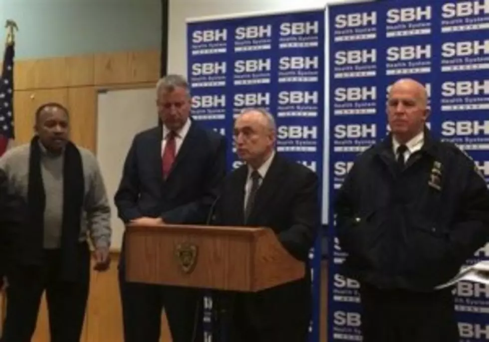 New York City Mayor Billl de Blasio, second left, stands by as Police Commissioner William Bratton, second right, speaks at a news conference at St. Barnabas Hospital in the Bronx